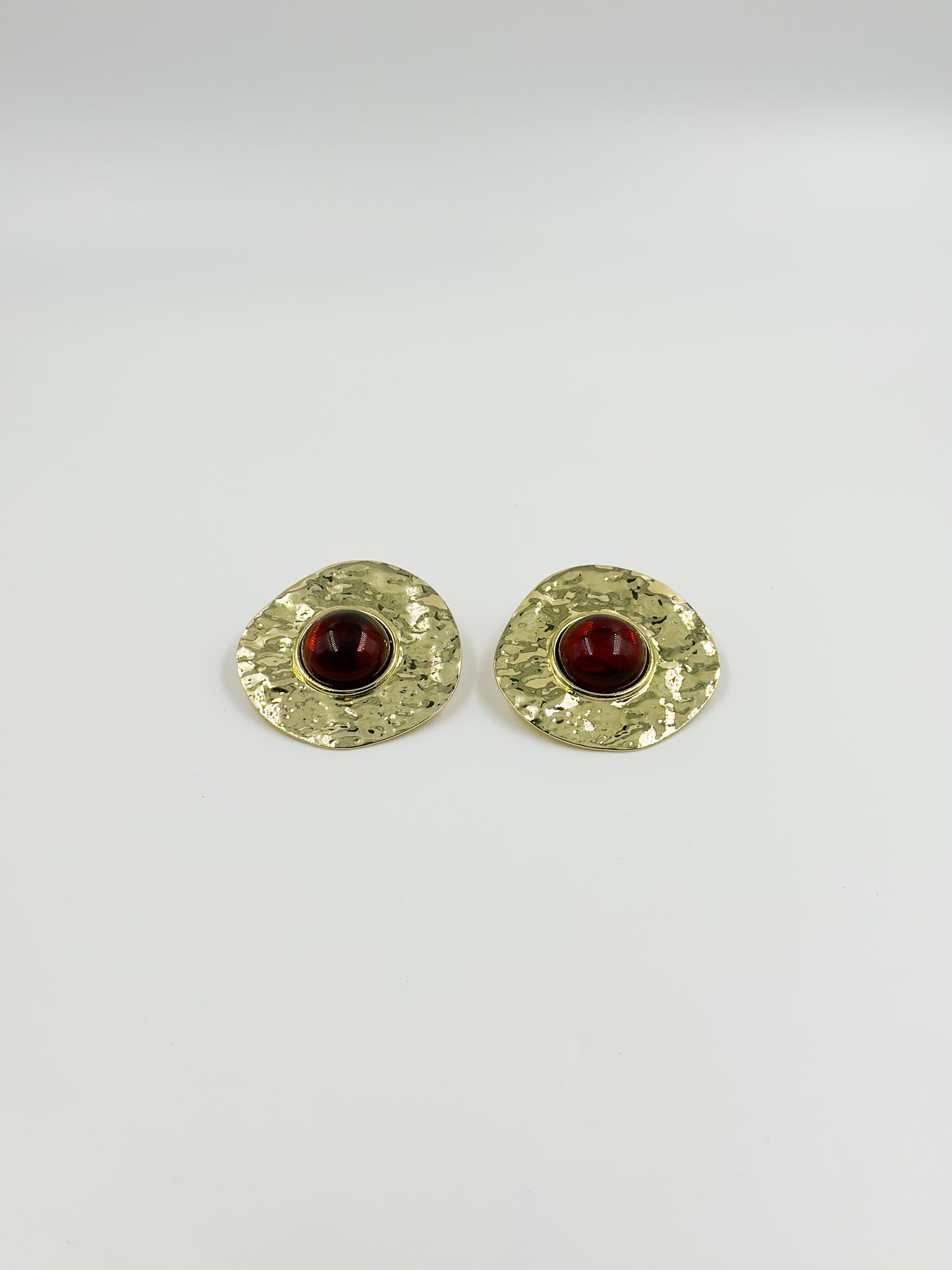 Gold earring and red central stone