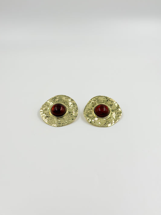 Gold earring and red central stone
