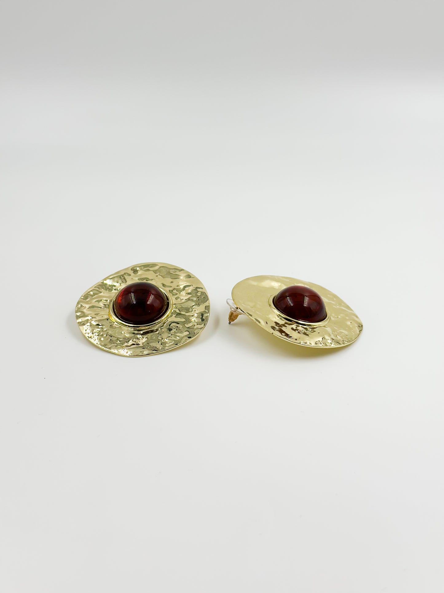 Gold earring and red central stone