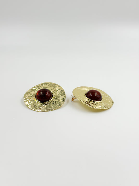 Gold earring and red central stone